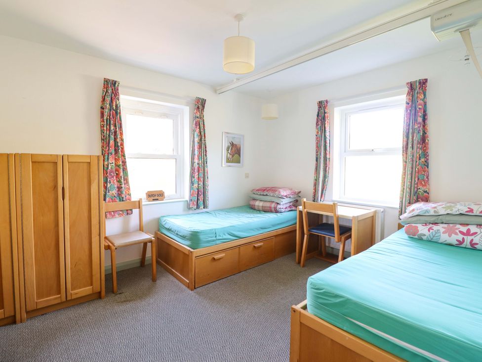 A bedroom with two beds and a table at Clwyd Special Riding Centre in Llanfynydd