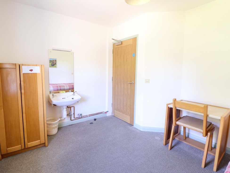 A bedroom with a sink and a cabinet at Clwyd Special Riding Centre in Llanfynydd