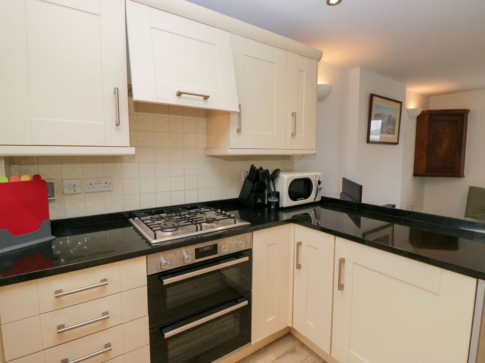 A kitchen with a gas stove and microwave at Swirl Howe in Keswick