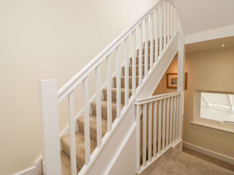 A staircase with a handrail and window at Swirl Howe in Keswick