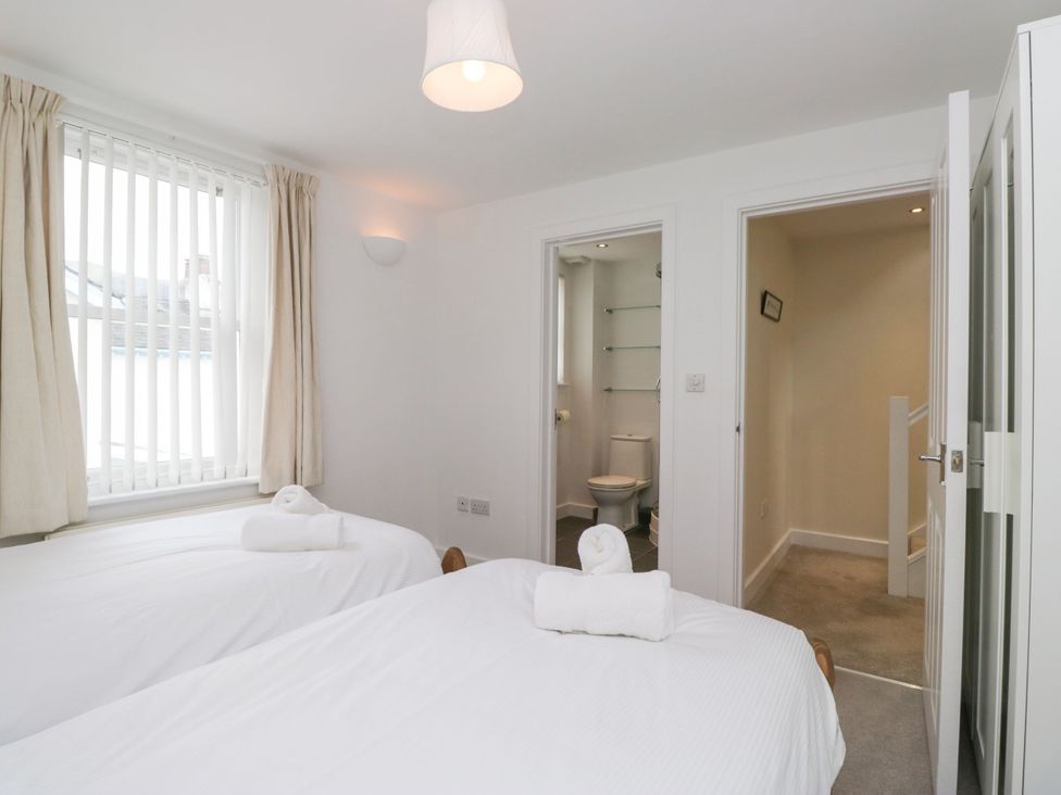A bedroom with two beds and an adjoining bathroom at Swirl Howe in Keswick