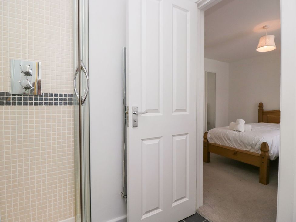 A bathroom with a shower and adjacent bedroom at Swirl Howe in Keswick