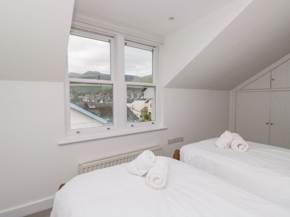 A bedroom with two beds and a view of the mountains at Swirl Howe, Keswick