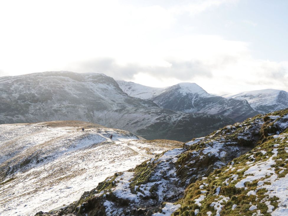 A scenic view of mountains and hikers on a trail at Swirl Howe in Keswick