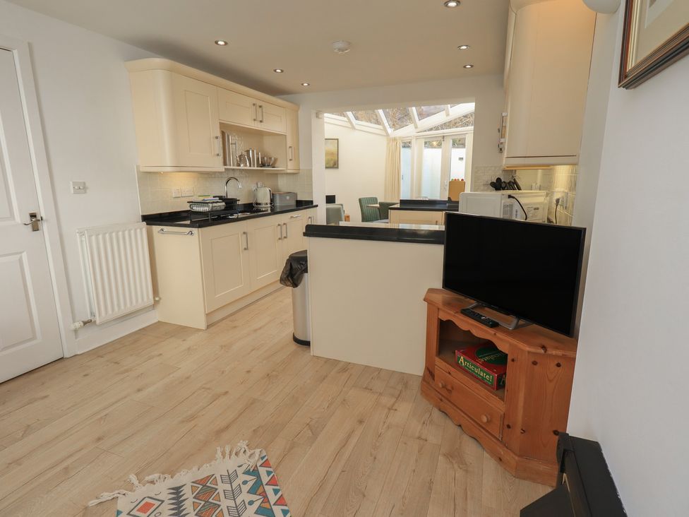 A kitchen with appliances including a sink and television at Swirl Howe in Keswick