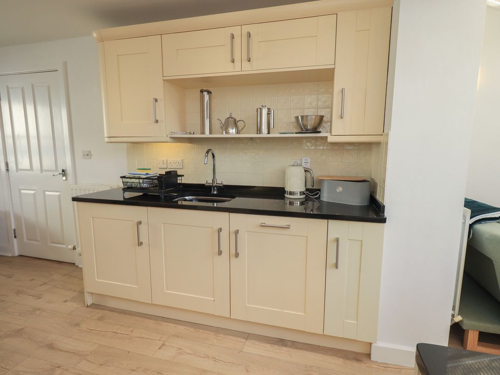 A kitchen with cabinets and a sink at Swirl Howe in Keswick