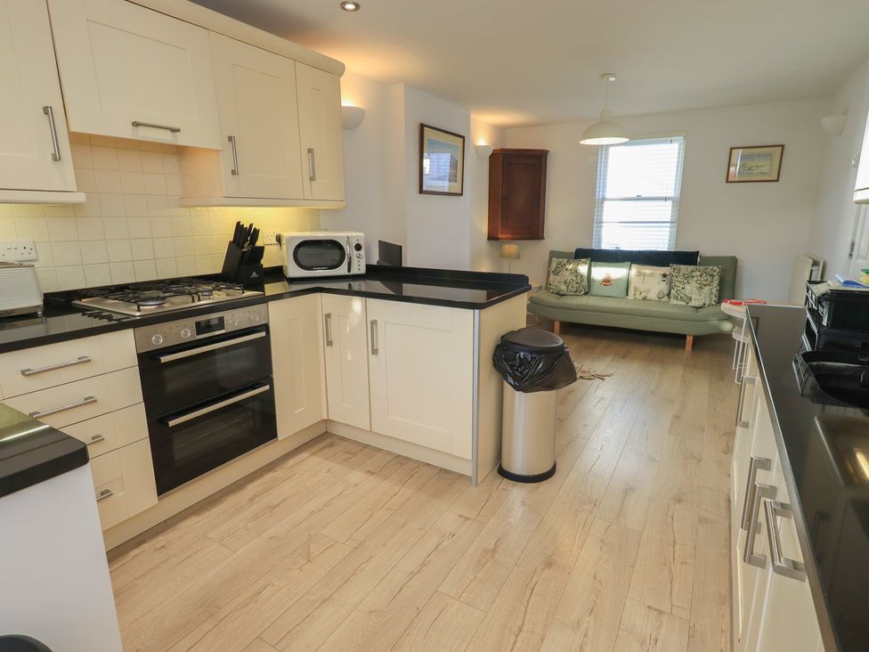 A kitchen with appliances and a sofa area at Swirl Howe in Keswick