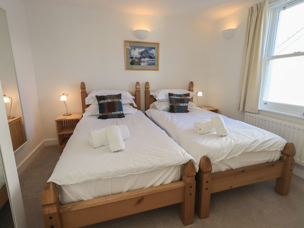 A bedroom with twin beds and bedside lamps at Swirl Howe in Keswick