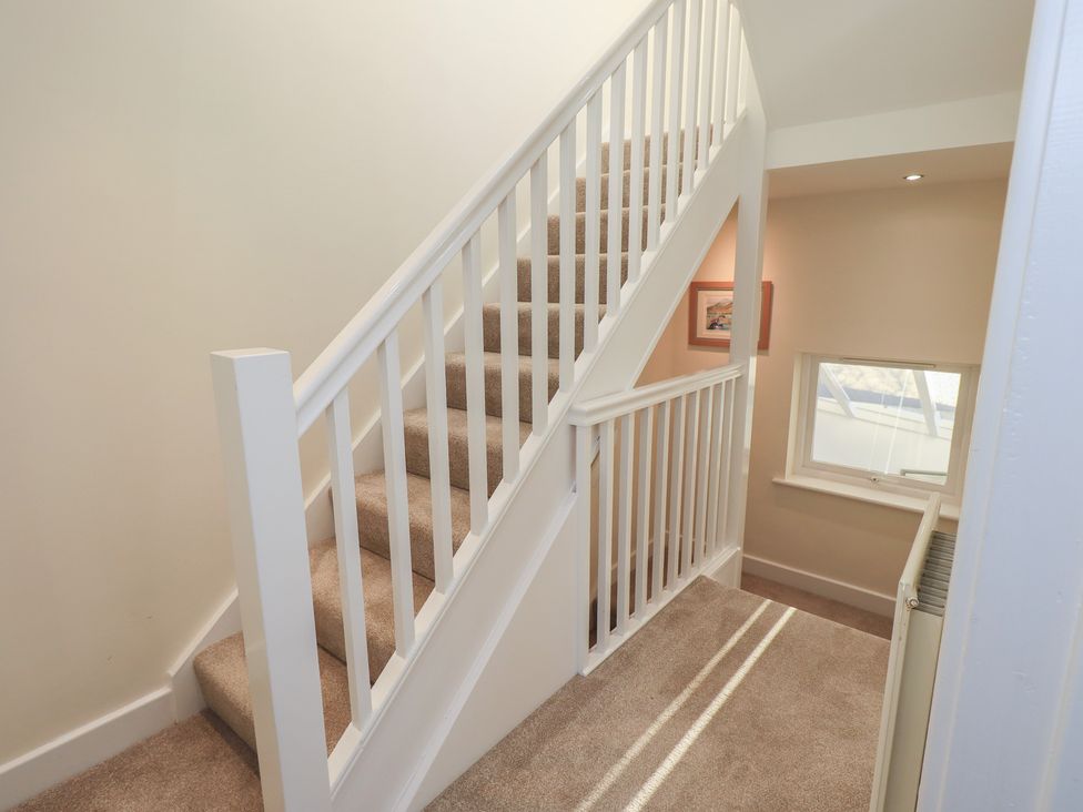 A staircase with a handrail and window at Swirl Howe in Keswick