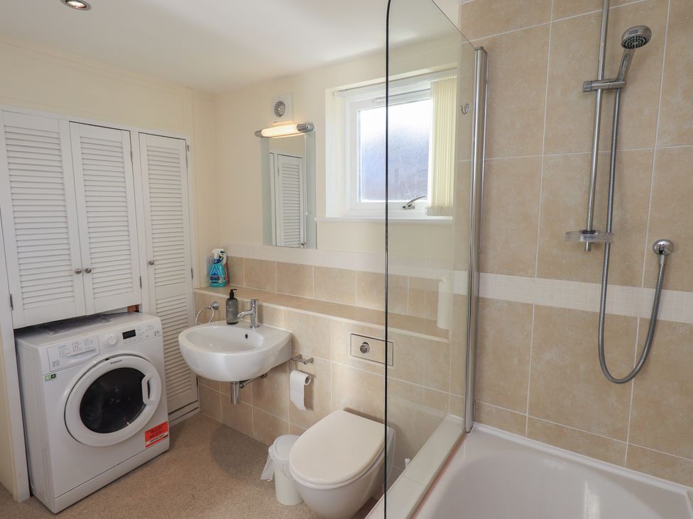 A bathroom with a washing machine and shower at Swirl Howe in Keswick