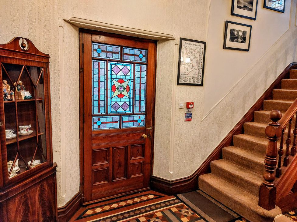 An entrance hall with a stained glass door and staircase at 1 Park Road Windermere