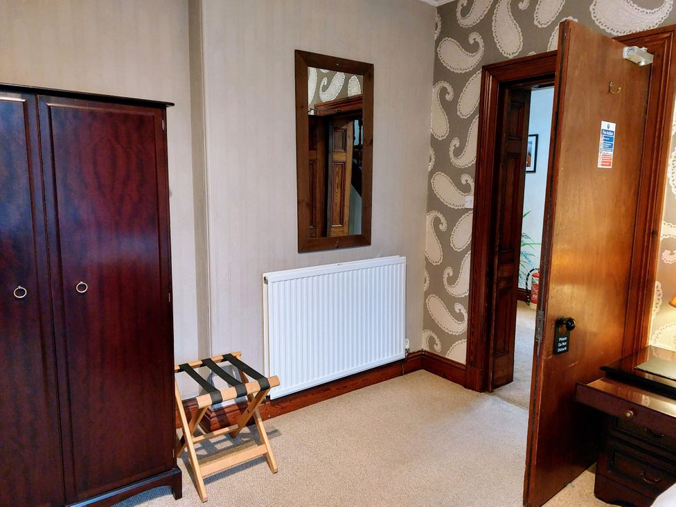 A bedroom with a wardrobe and a mirror at 1 Park Road in Windermere