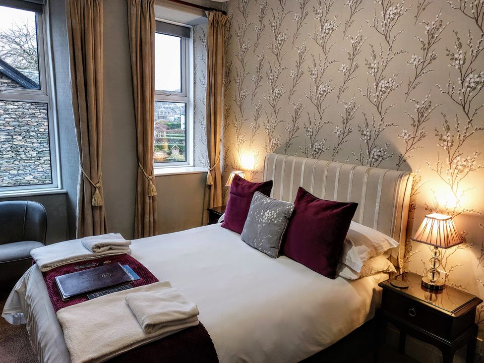 A bedroom with a bed and lamps at 1 Park Road Windermere