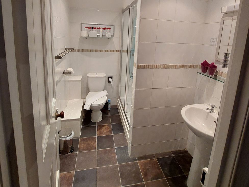 A bathroom with a shower, sink, and toilet at 1 Park Road in Windermere