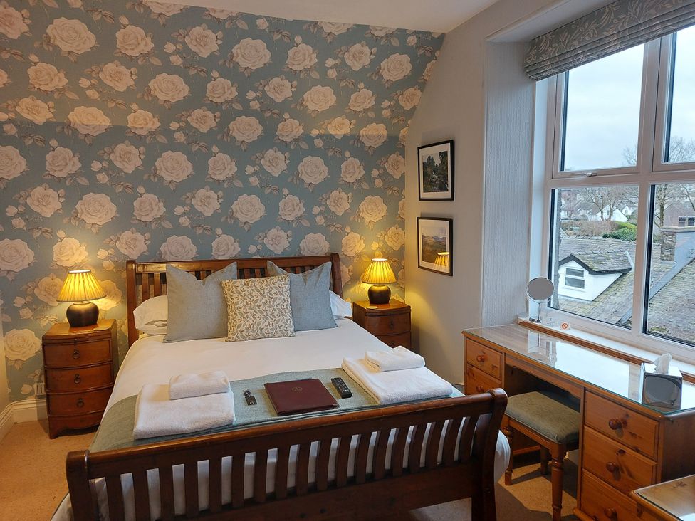 A bedroom with a bed and desk at 1 Park Road in Windermere