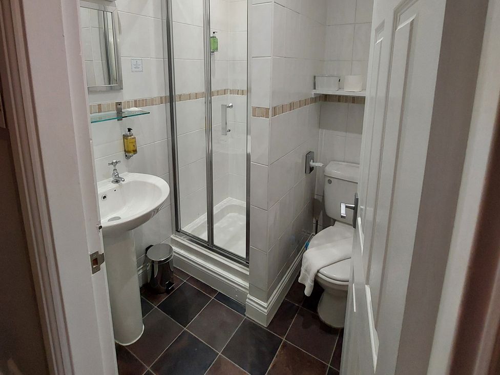 A bathroom with a shower, sink, and toilet at 1 Park Road in Windermere