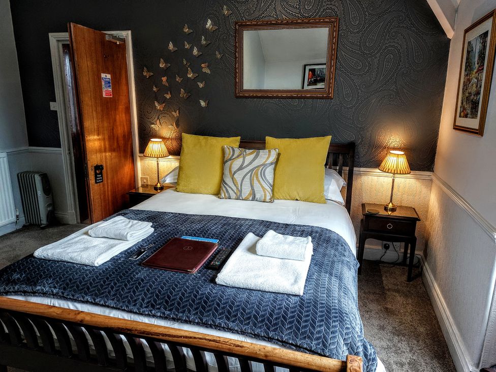 A bedroom with a bed and bedside lamps at 1 Park Road Windermere