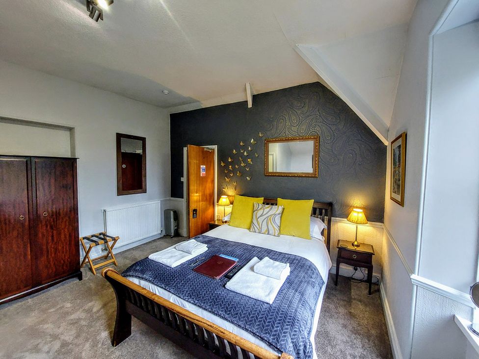 A bedroom with a bed and furniture at 1 Park Road in Windermere