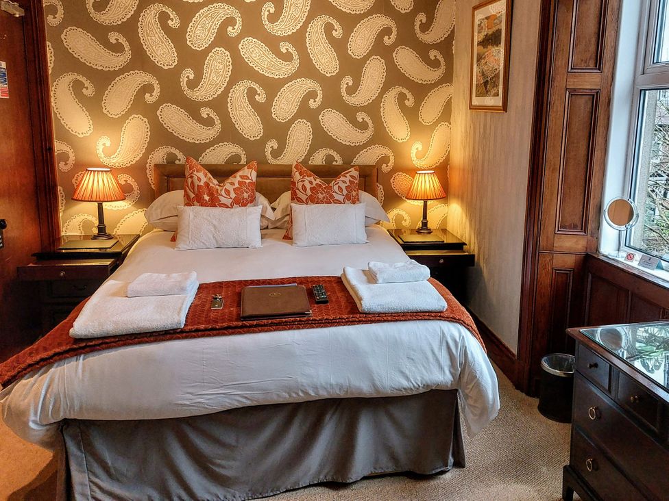 A bedroom with a bed and lamps at 1 Park Road Windermere