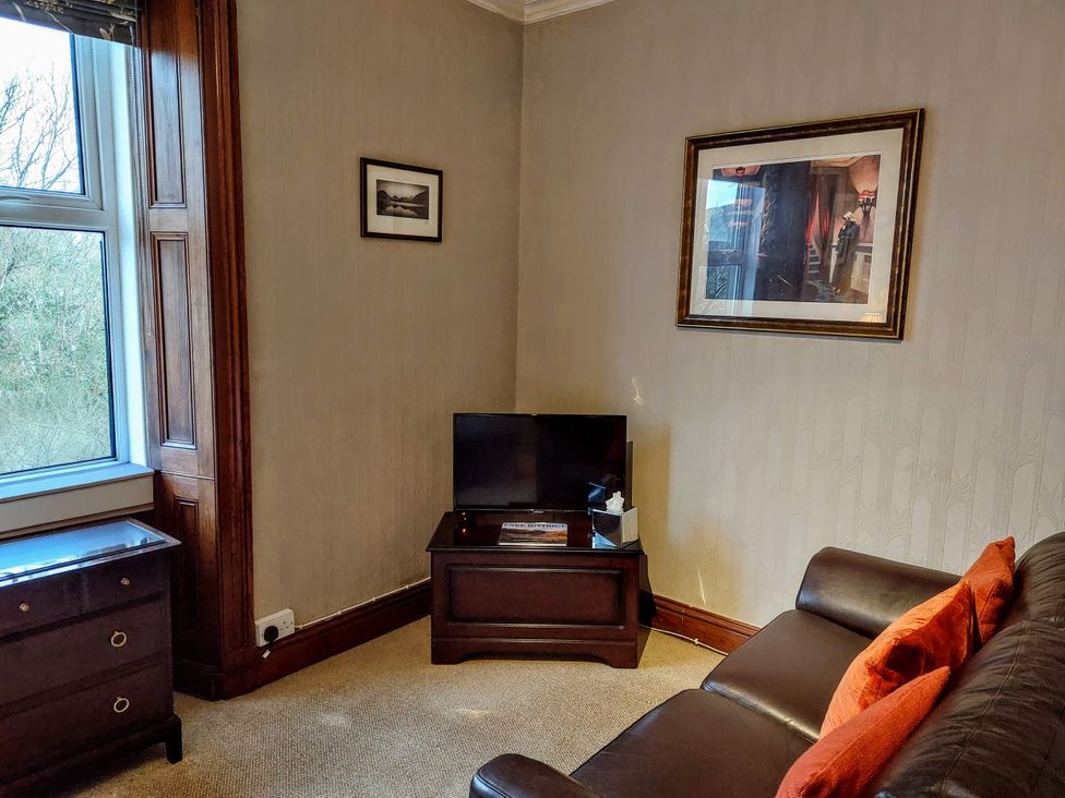 A living room with a sofa and television at 1 Park Road Windermere