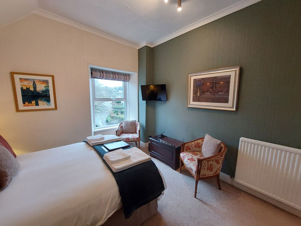 A bedroom with a bed and artwork at 1 Park Road Windermere
