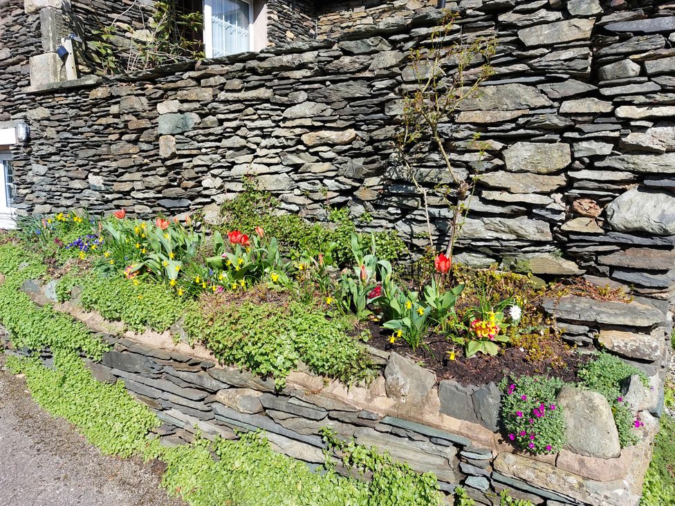 A garden bed with flowers beside a stone wall at 1 Park Road Windermere