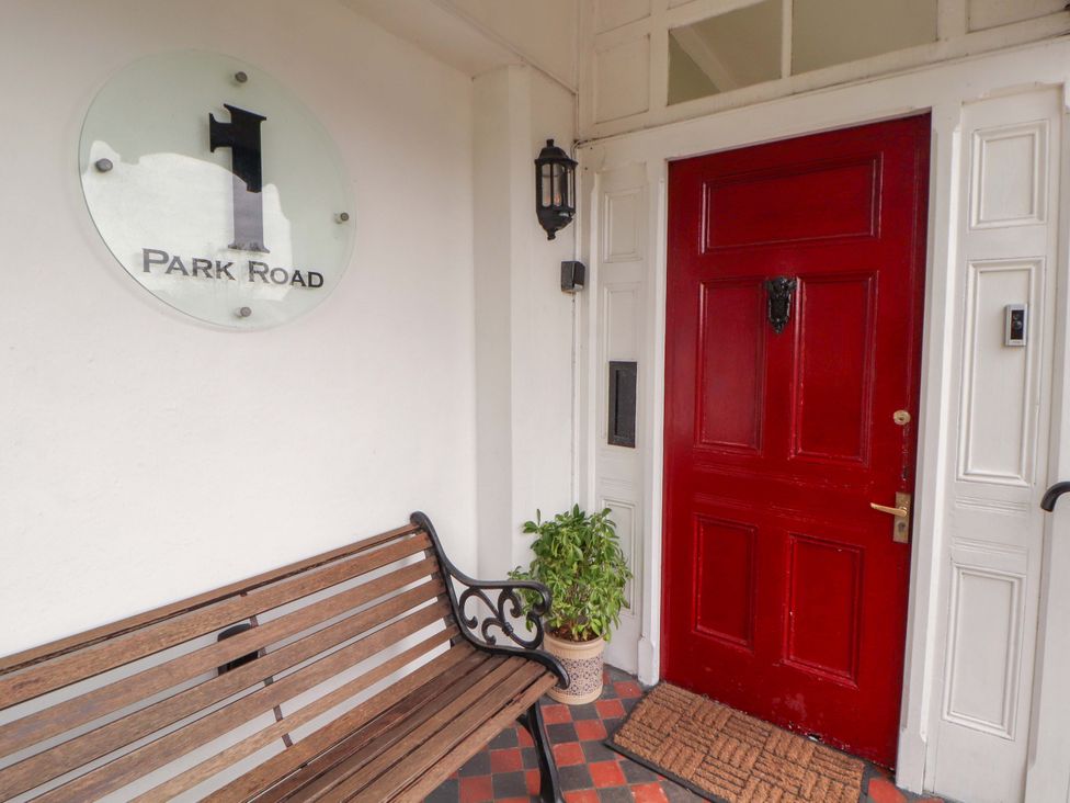An entrance with a bench and red door at 1 Park Road in Windermere