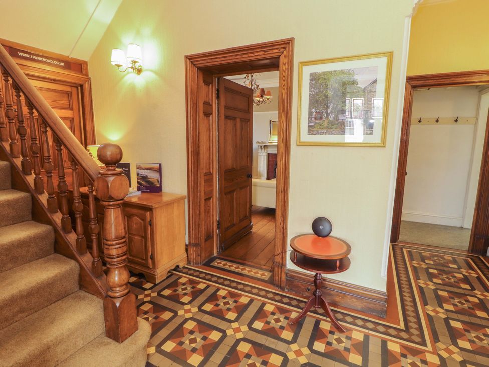 A hallway with a staircase and decorative floor tiles at 1 Park Road Windermere
