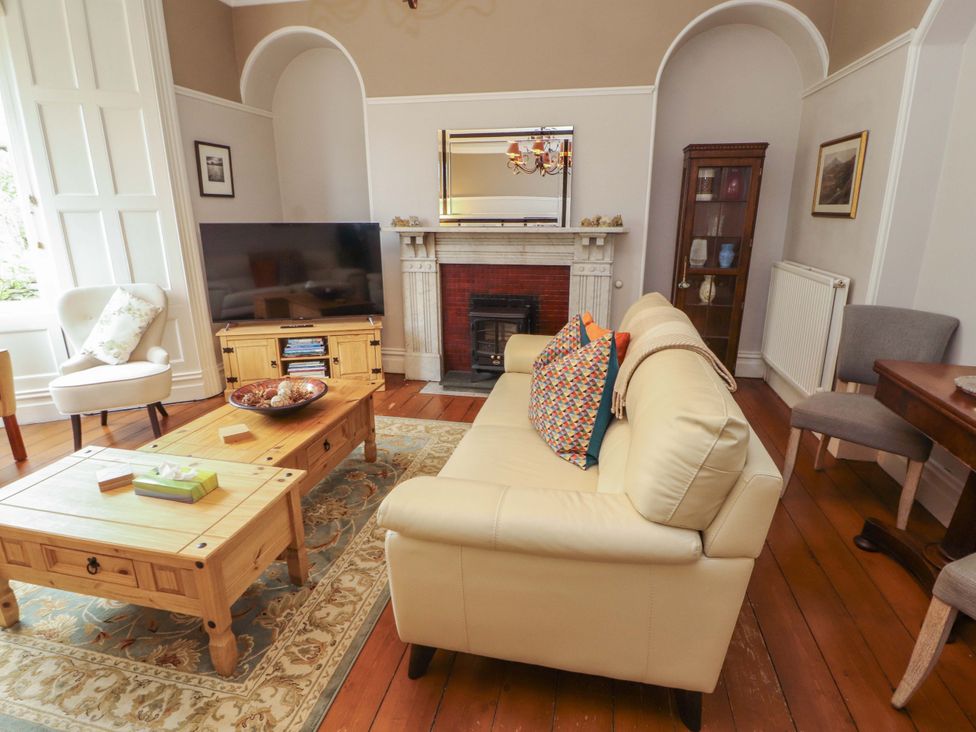 A living room with a sofa and television at 1 Park Road in Windermere