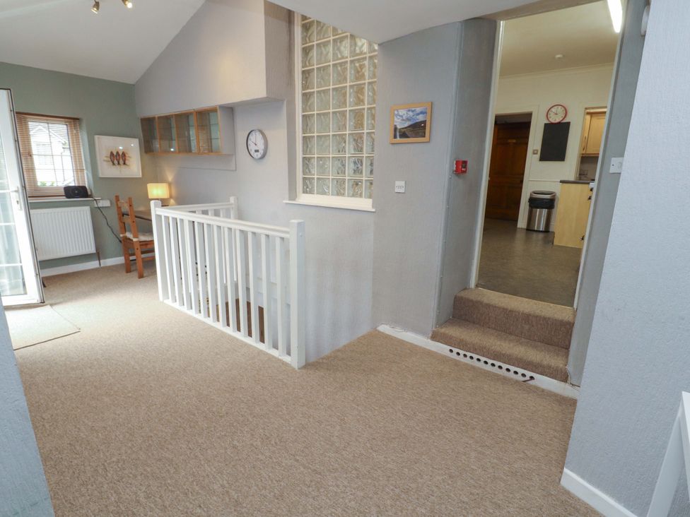 A hallway with a staircase and clock at 1 Park Road in Windermere