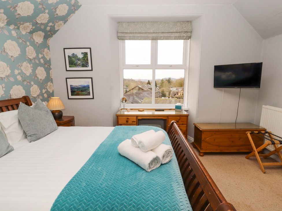A bedroom with a window and television at 1 Park Road in Windermere