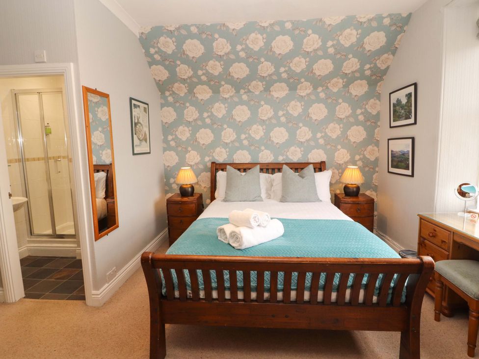 A bedroom with a bed and a shower at 1 Park Road Windermere