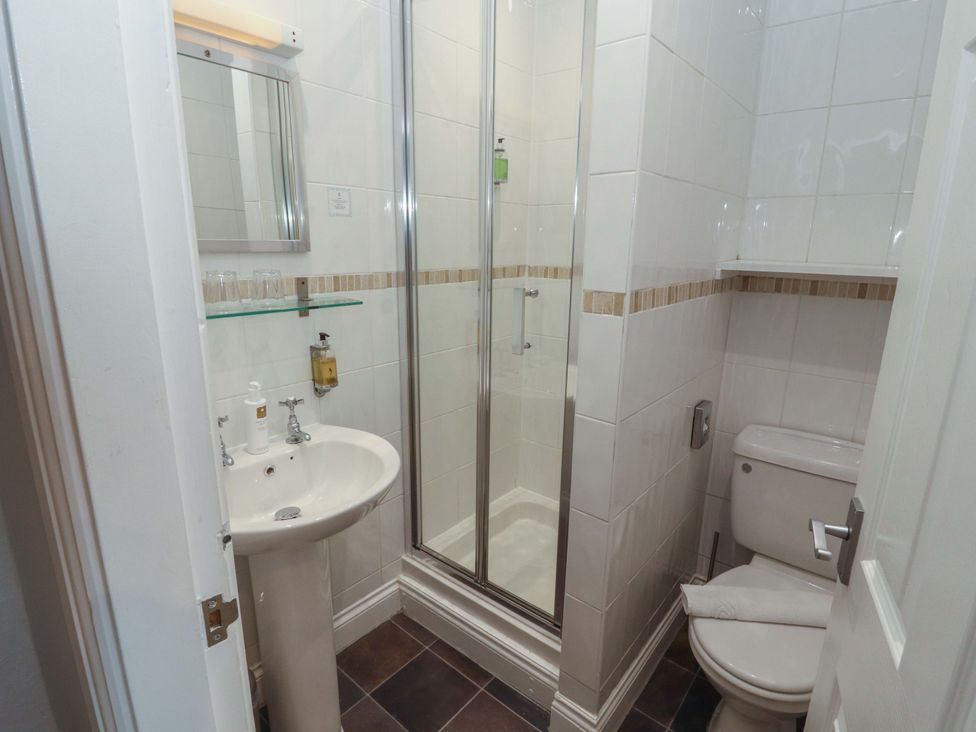 A bathroom with a shower, sink, and toilet at 1 Park Road in Windermere