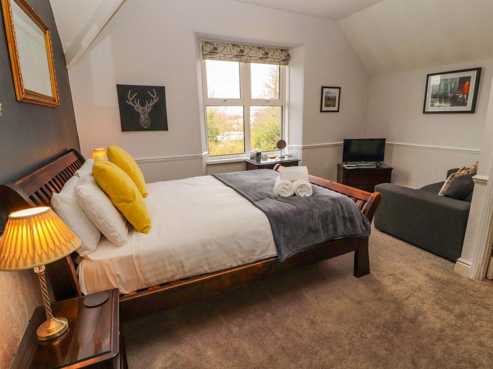 A bedroom with a bed and artwork at 1 Park Road Windermere