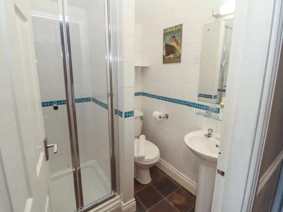 A bathroom featuring a shower, toilet, and sink at 1 Park Road in Windermere