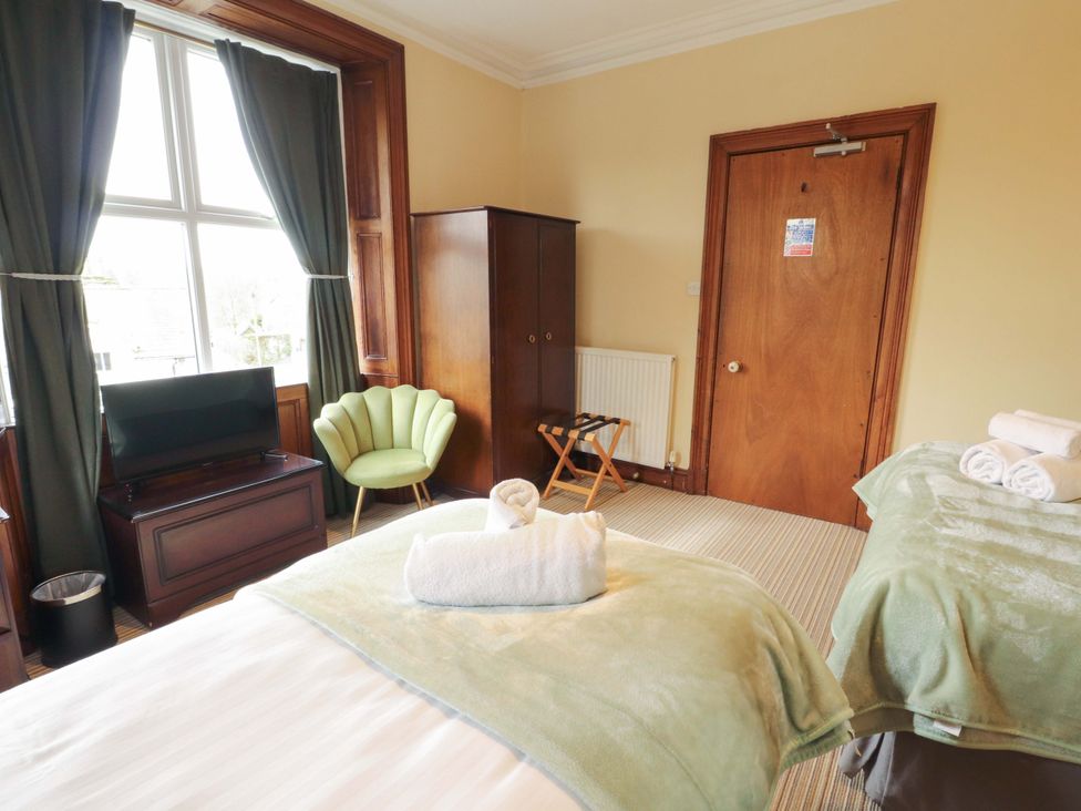 A bedroom with a bed and television at 1 Park Road Windermere