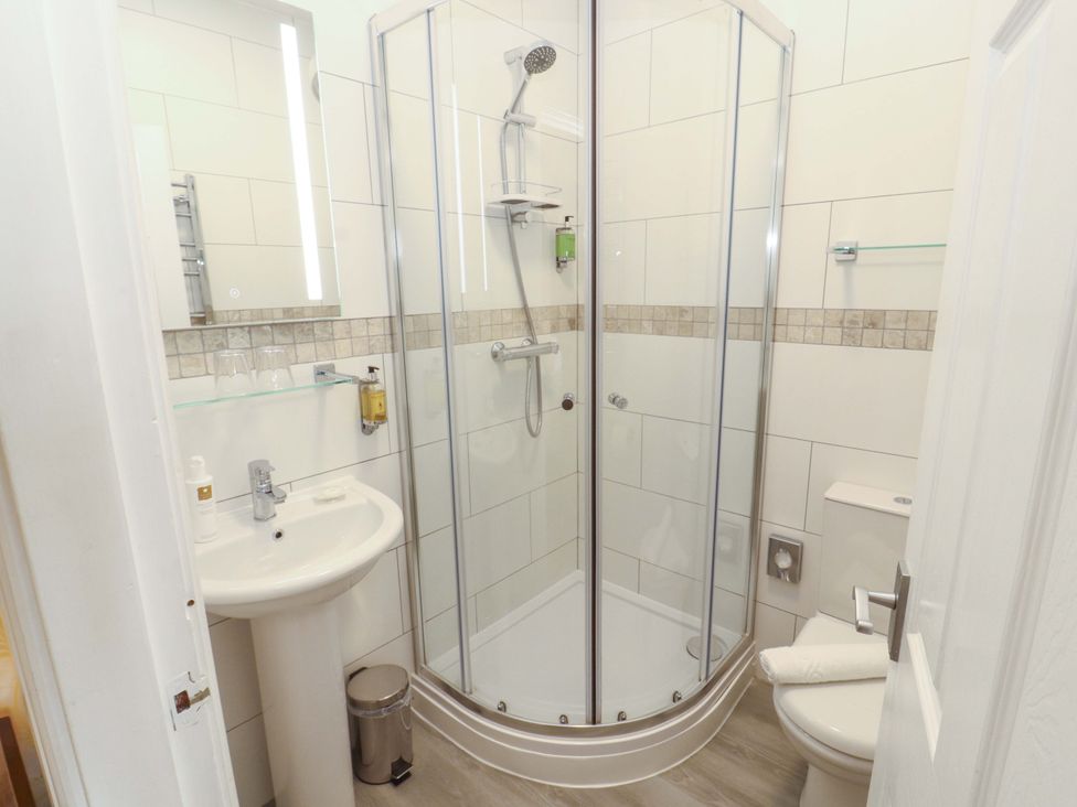 A bathroom with a shower, sink, and toilet at 1 Park Road Windermere