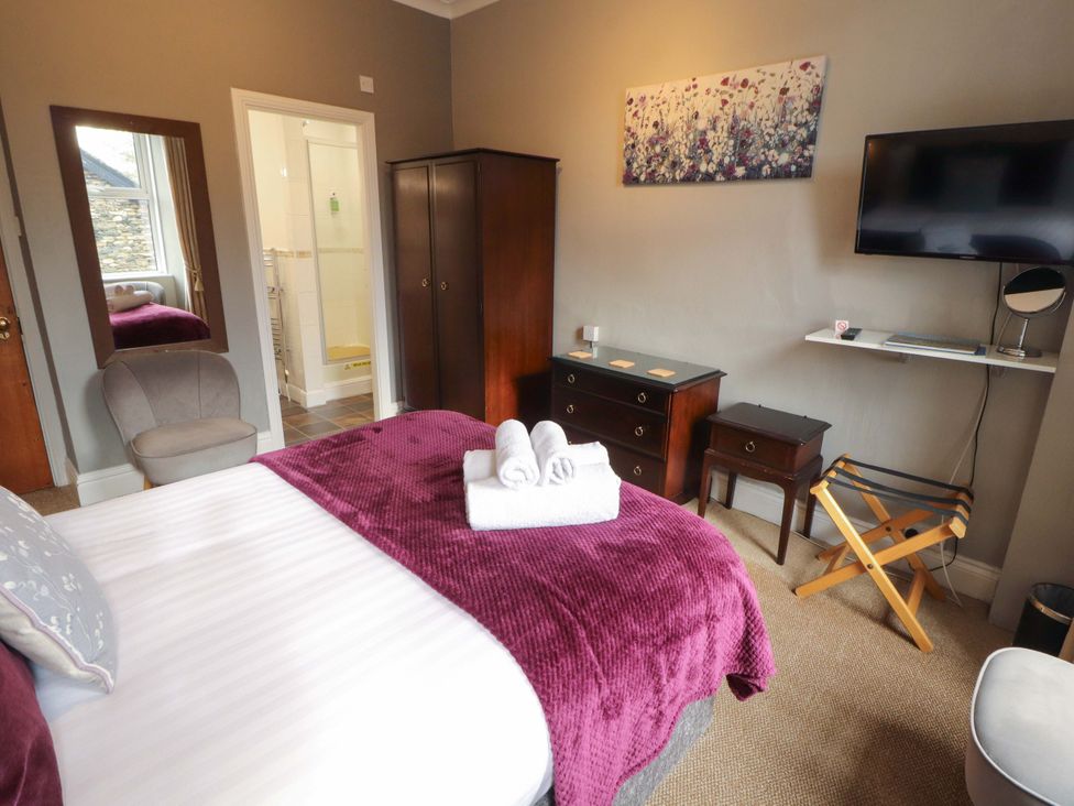 A bedroom with a bed and towels at 1 Park Road in Windermere