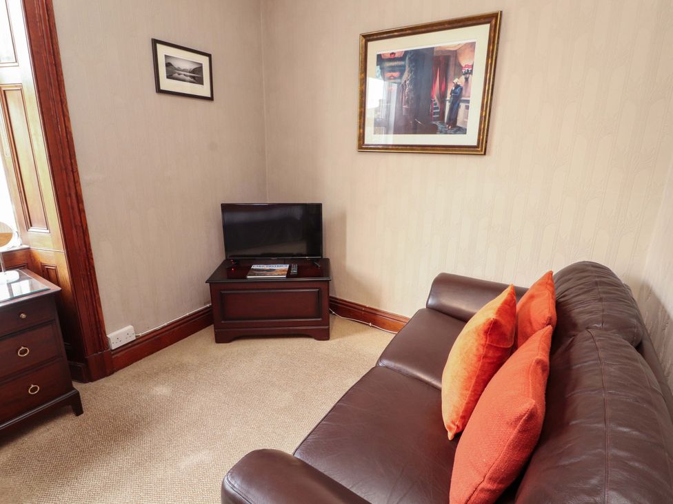 A living room with a sofa and television at 1 Park Road Windermere