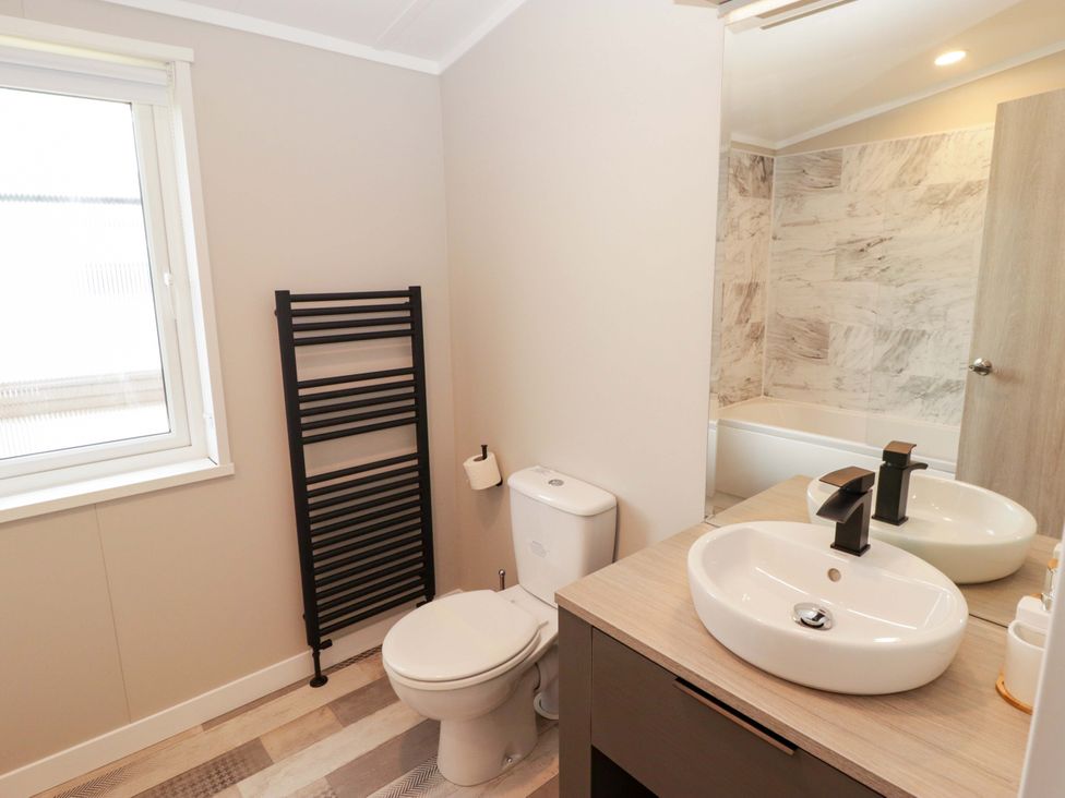 A bathroom with a toilet, sink, and bathtub at Dolphin in Haverfordwest