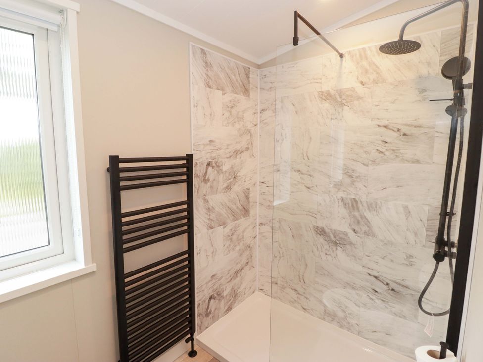 A bathroom with a glass shower and towel warmer at Dolphin in Haverfordwest