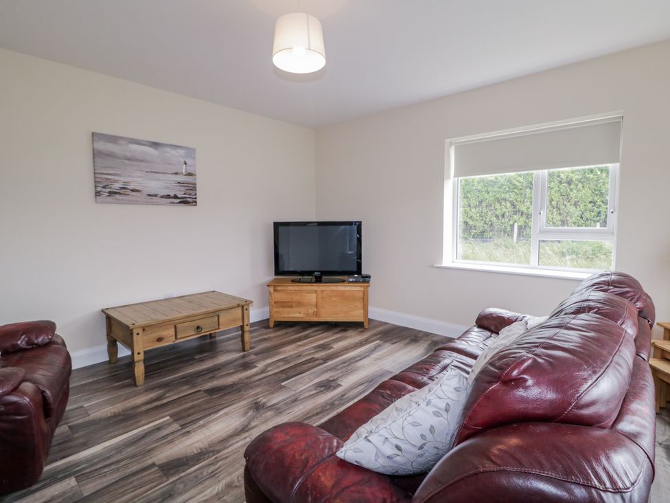 A living room with a television and a coffee table at Teac Caoimhe in Falcarragh