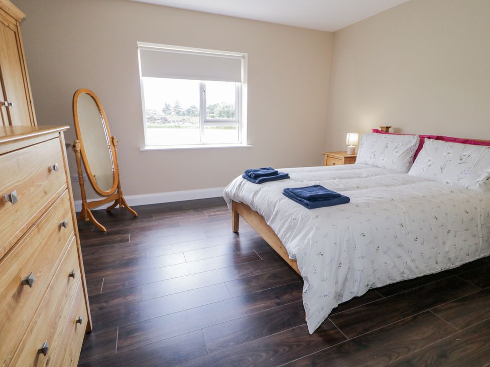 A bedroom with a bed and a mirror at Teac Caoimhe in Falcarragh
