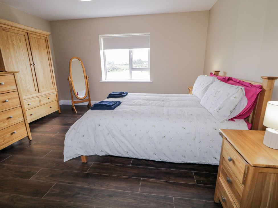 A bedroom with two beds and a wardrobe at Teac Caoimhe in Falcarragh