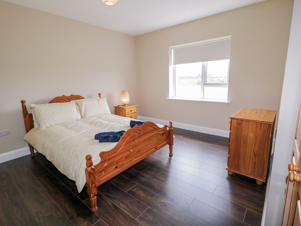 A bedroom with a bed, a lamp, and a dresser at Teac Caoimhe Falcarragh