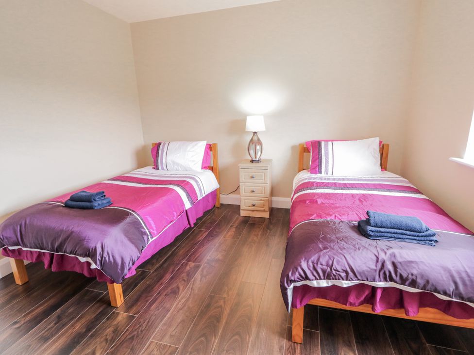 A bedroom with two beds and a bedside table at Teac Caoimhe in Falcarragh