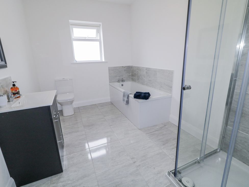 A bathroom with a bathtub, shower, and toilet at teac Caoimhe in Falcarragh