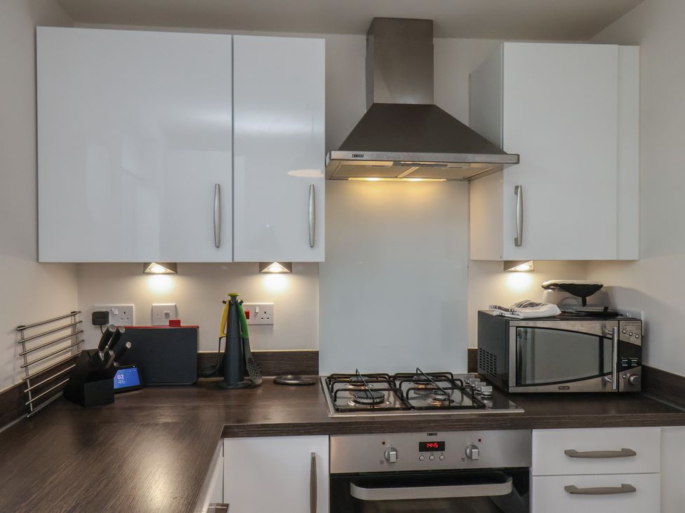 A kitchen with cabinets and cooking appliances at Larpool Retreat