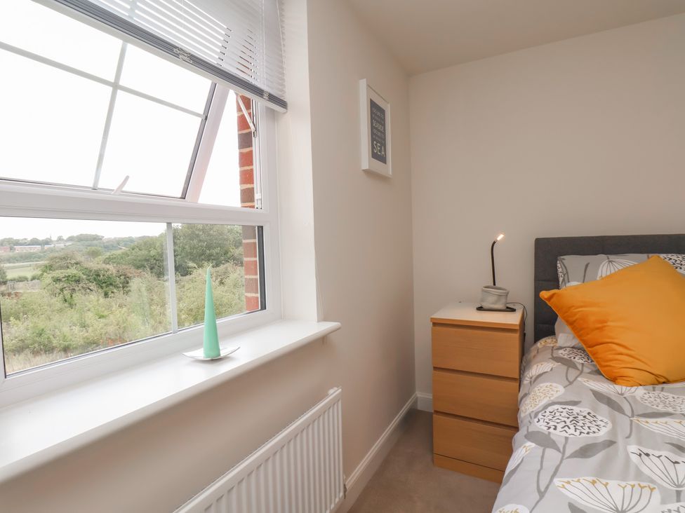A bedroom with a window and a nightstand at Larpool Retreat 
