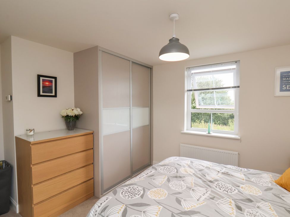 A bedroom with a bed, wardrobe, and window at Larpool Retreat 